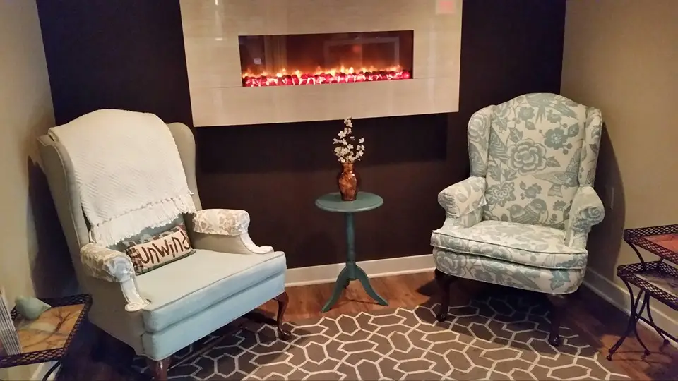 Fireplace lounge area at Table for One Spa in Cedar Rapids